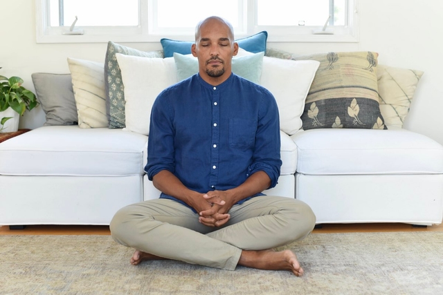 Man meditating in home